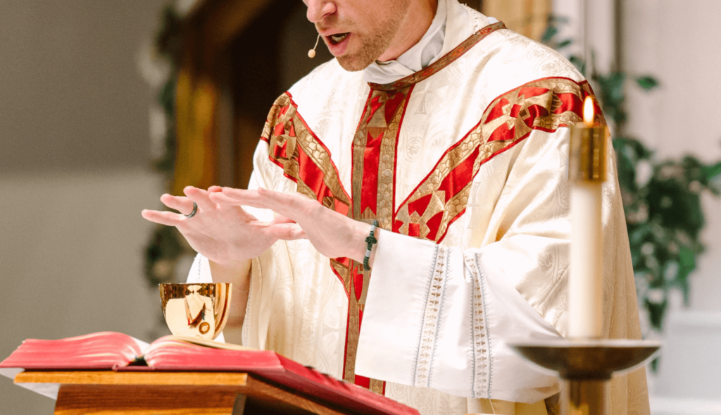 A young priest at the altar praying the Eucharistic consecration.