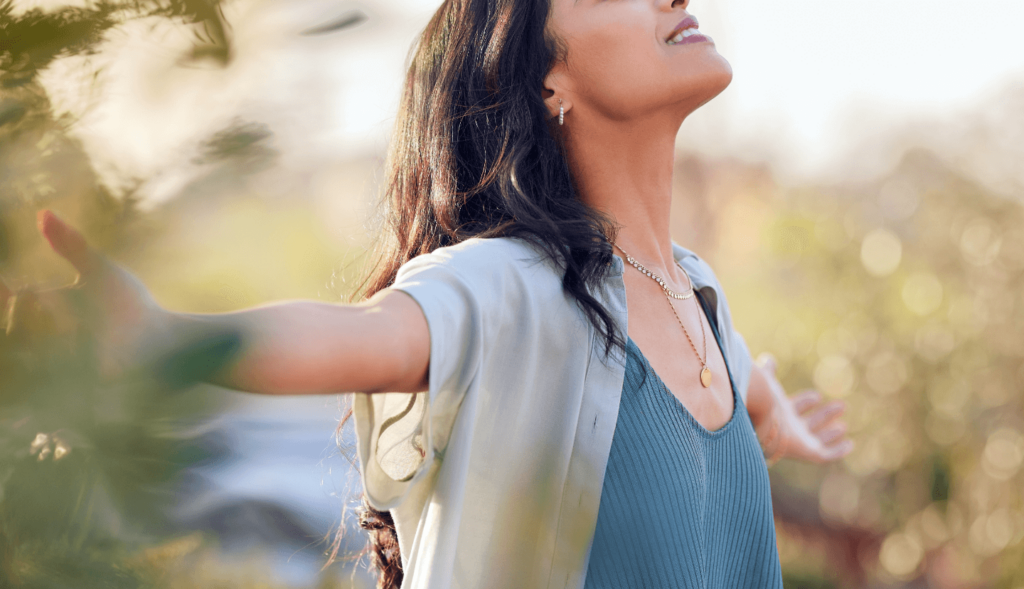 A woman with her face turned upward smiling.