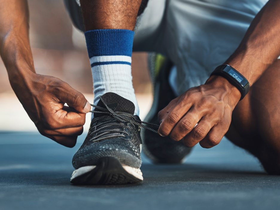 Runner kneels to tie his shoe.