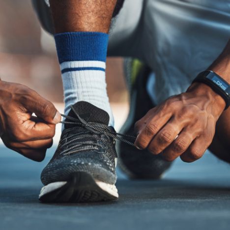 Runner kneels to tie his shoe.